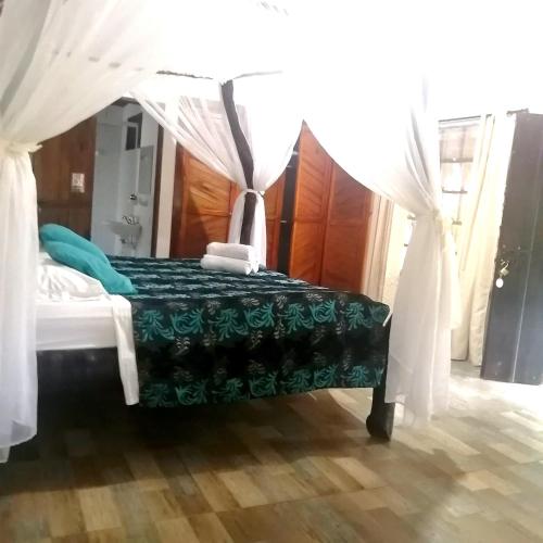 a bedroom with a bed with a canopy at Hostal Villa Cata in El Zaino