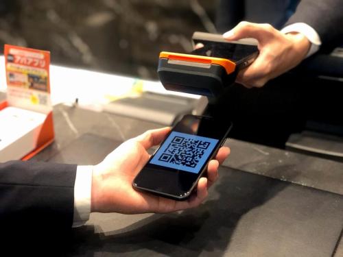 a person holding a cell phone in a store at APA Hotel Maebashieki-Kita in Maebashi