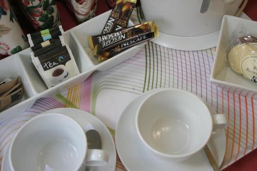 ein Tisch mit weißen Tassen und Untertassen darauf in der Unterkunft Kirklands House in Melrose