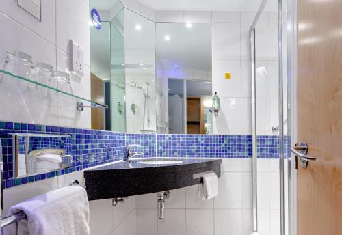 a bathroom with a sink, mirror, and bathtub at Holiday Inn Express - Glasgow - City Ctr Theatreland, an IHG Hotel in Glasgow