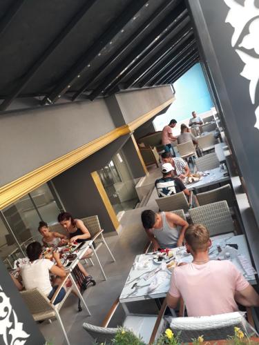 een groep mensen die aan tafels in een restaurant zitten bij MOONBOW BEACH HOTEL in Alanya