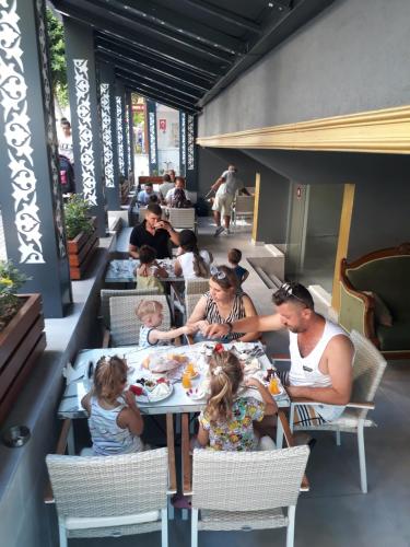 een groep mensen die aan een tafel in een restaurant zitten bij MOONBOW BEACH HOTEL in Alanya