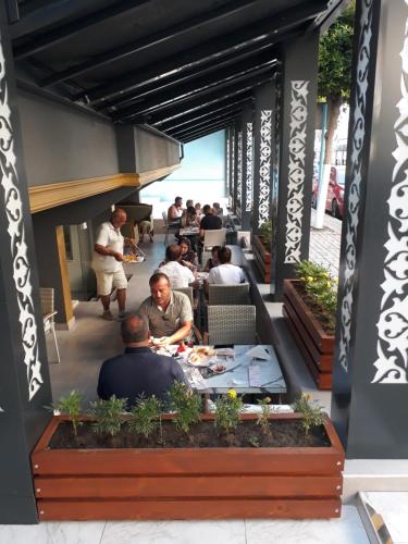 een groep mensen die aan tafels in een restaurant zitten bij MOONBOW BEACH HOTEL in Alanya