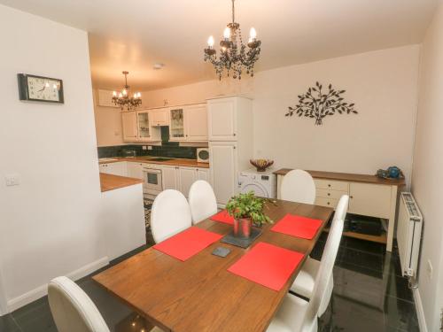a kitchen with a wooden table and white cabinets at The Old Mill in Milford Haven