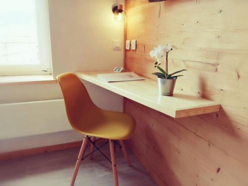 a desk with a chair and a plant on it at Hotel Les Montagnards in Morteau