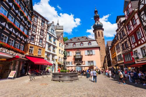a city street with buildings and a clock tower at Moselstern-Hotel "Weinhaus Fuhrmann" in Ellenz-Poltersdorf