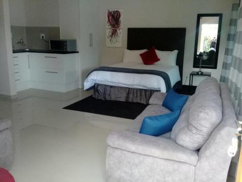 a living room with a couch and a bed at Apollo Hotel in Johannesburg
