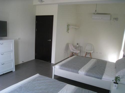 a bedroom with a bed and a dresser and a television at Penghu 123 V-Stone in Magong