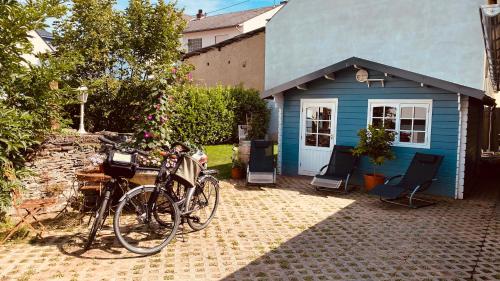 a bike parked in front of a blue house at Moselstern-Hotel "Weinhaus Fuhrmann" in Ellenz-Poltersdorf