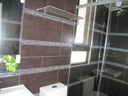 a bathroom with a toilet and a glass shower at Penghu 123 V-Stone in Magong