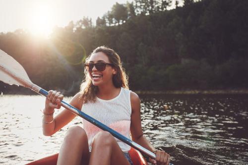 a woman is rowing a boat on a lake at Moselstern-Hotel "Weinhaus Fuhrmann" in Ellenz-Poltersdorf