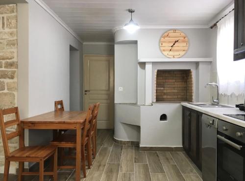 cocina con mesa y reloj en la pared en Villa Antonis, en Lákka