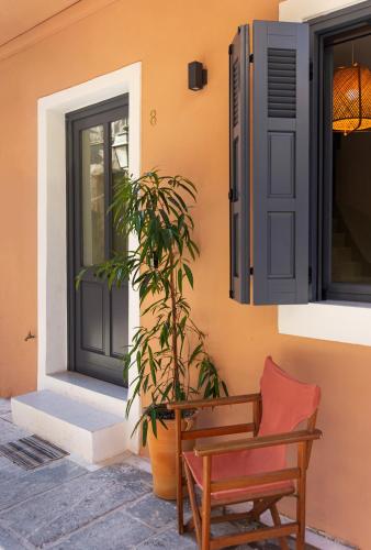a house with a chair and a plant next to a door at Orestis downtown home in Rethymno