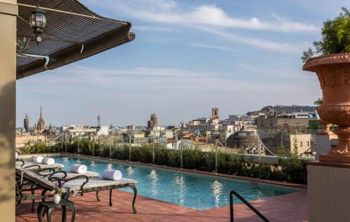 a swimming pool with a view of a city at Hotel El Palace Barcelona in Barcelona