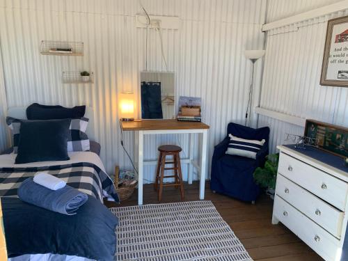a bedroom with two beds and a desk and a stool at Evanston Station in Ilfracombe