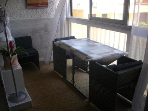 uma mesa e cadeiras num quarto com uma janela em PALMA II em Port-la-Nouvelle
