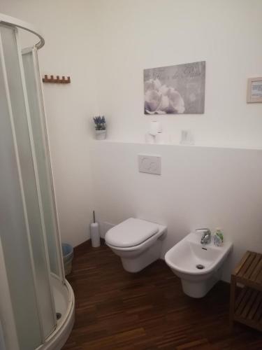 ein weißes Bad mit einem WC und einem Waschbecken in der Unterkunft B&B Longara in Calderara di Reno