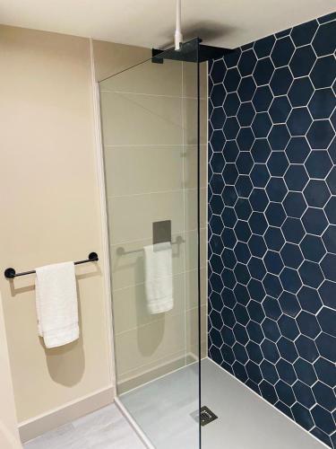 a bathroom with a shower with blue tiles at Wildes Inns in Chesterfield