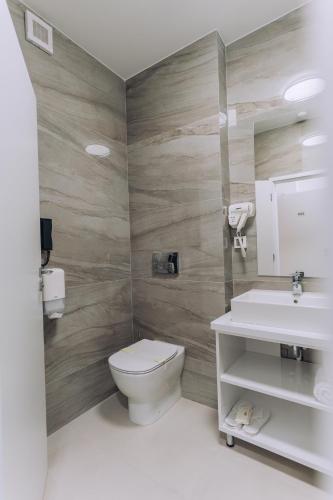 a bathroom with a toilet and a sink at Hotel Perla in Baile Unu Mai