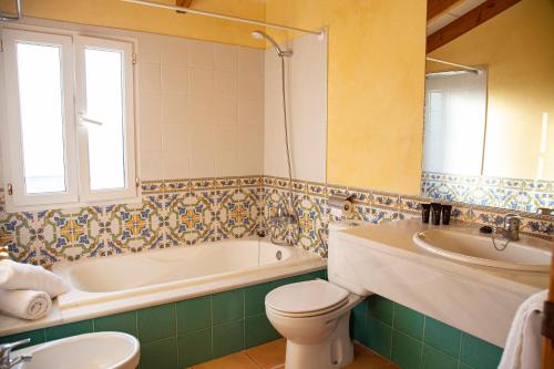 a bathroom with a tub and a toilet and a sink at Sagitario Villas in Son Carrio