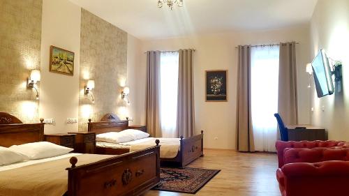 une chambre d'hôtel avec deux lits et un canapé dans l'établissement Euro Aparthotel, à Tarnów