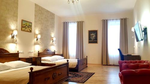 una habitación de hotel con dos camas y un sofá en Euro Aparthotel, en Tarnów