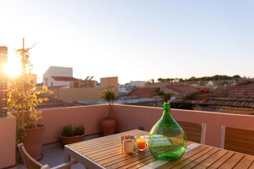 a wooden table with a glass bottle on a balcony at Orestis downtown home in Rethymno Town