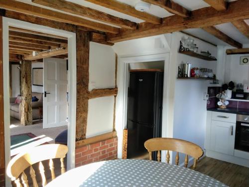a kitchen with a table and chairs and a black refrigerator at Little Drift in Edgton