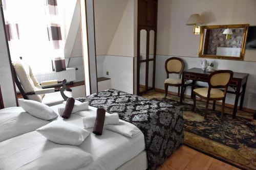 a hotel room with two beds and a table at Śnieżka in Krosno