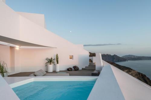 a pool in a house with a view of the water at The Saint Hotel in Oia