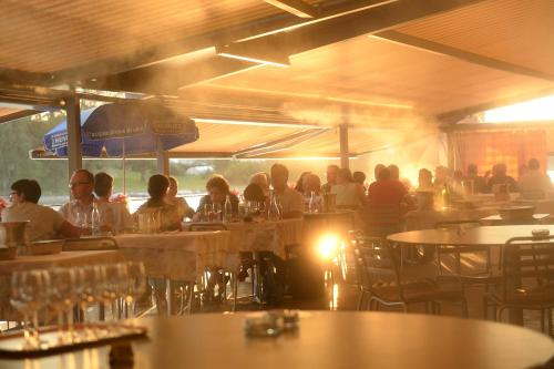a group of people sitting at tables in a restaurant at Hotel Rheinfels in Stein am Rhein