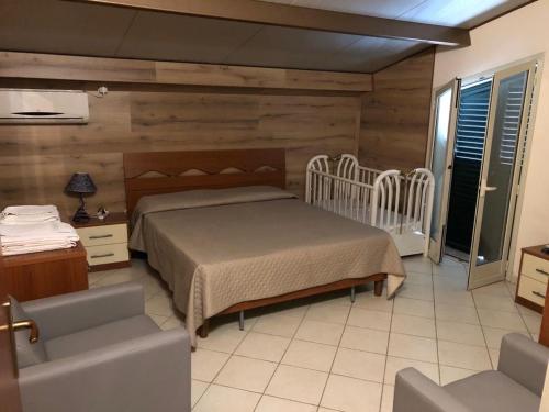 1 dormitorio con 1 cama, 1 sofá y 1 silla en villa aurora, en Francavilla di Sicilia