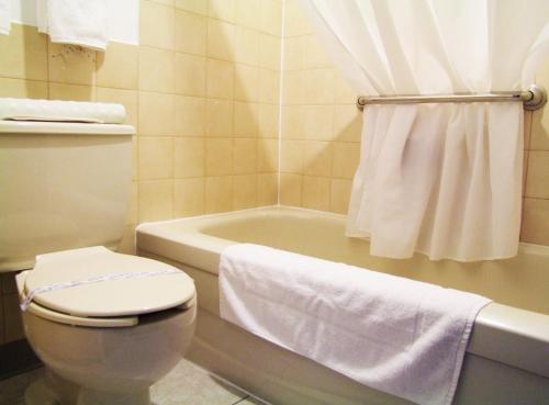y baño con aseo blanco y bañera. en Motel à la Brunante, en Sainte-Anne-des-Monts