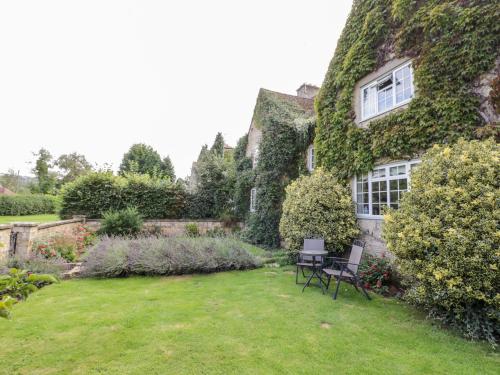 a garden with two chairs in front of a house at The Malins in Moreton in Marsh