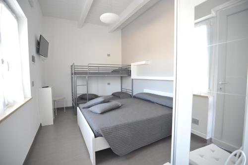 a white bedroom with a bunk bed and a mirror at Agriturismo Frontemare in Giulianova