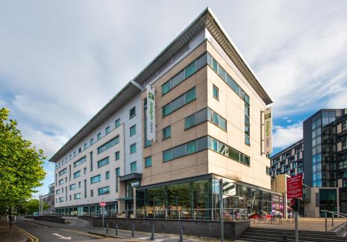 a large building with glass windows on a street at Holiday Inn Express Leeds City Centre - Armouries by IHG in Leeds