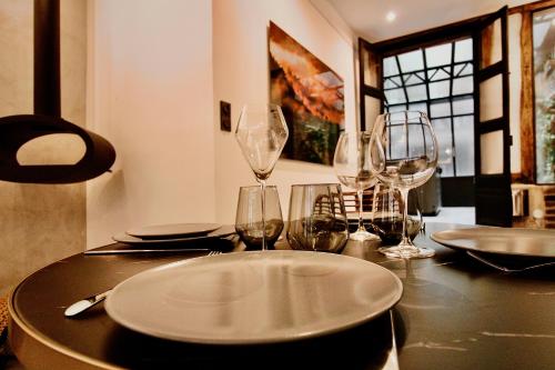 a table with wine glasses and plates on it at L'Atelier 1742 - Atypique jacuzzi Rouen Centre in Rouen