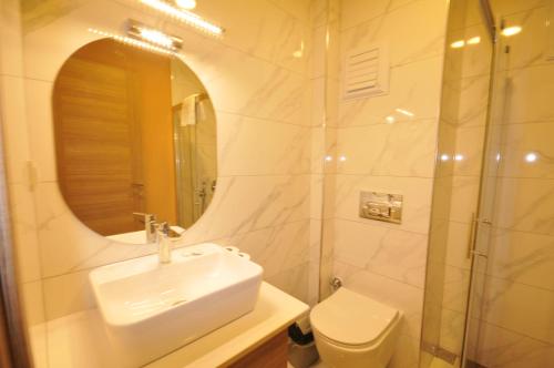 Un baño con lavabo, espejo e inodoro. en Isla Apart, en Marmaris