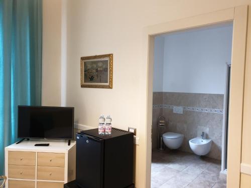 a bathroom with a television and a bathroom with a toilet at Lady Verona Residence in Verona
