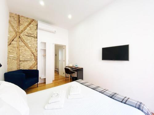 a bedroom with a bed and a tv on a wall at The Postcard Lisbon in Lisbon