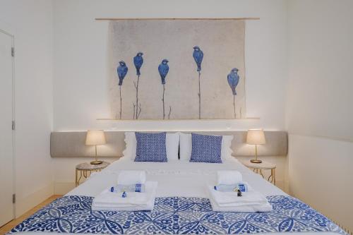 um quarto com uma cama grande com lençóis azuis e brancos em BOUTIQUE Rentals-Flores Terrace historical centre no Porto