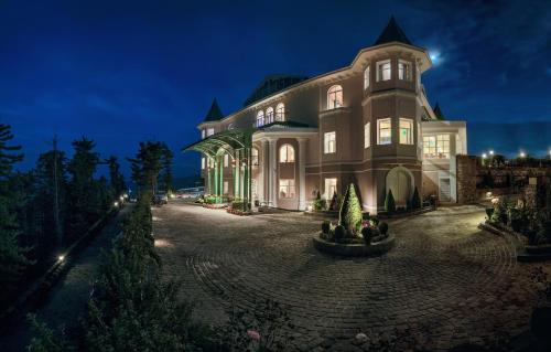a large house at night with its lights on at Club Mahindra Pristine Peaks Naldehra in Shimla