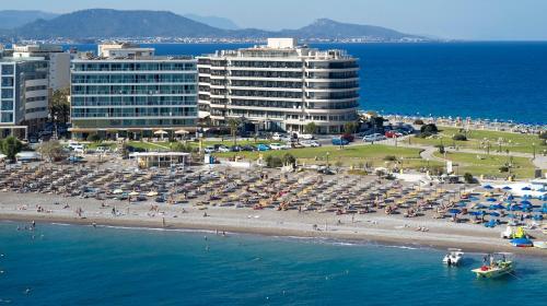 a beach with umbrellas and people on the beach at Aquarium View Hotel in Rhodes Town
