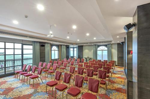 a conference room with chairs and a stage in the middle at Club Mahindra Pristine Peaks Naldehra in Shimla