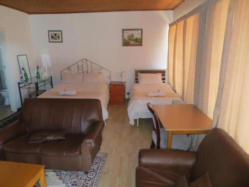 a living room with two beds and a couch at The Swiss Guesthouse in Johannesburg