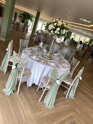a long table with chairs and flowers on it at Wildes Inns in Chesterfield
