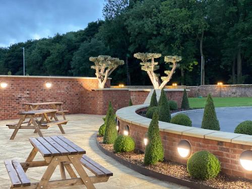 a patio with two picnic tables and a fountain at Wildes Inns in Chesterfield