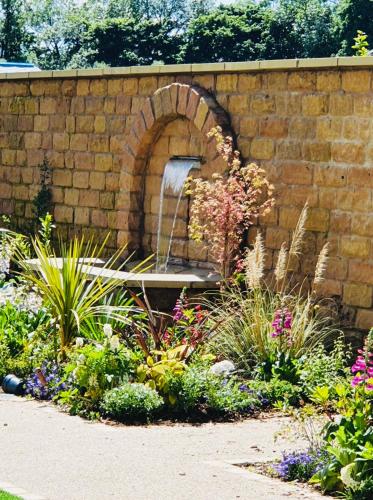 a garden with a fountain in a brick wall at Wildes Inns in Chesterfield