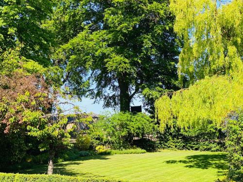 a garden with green grass and trees and a field at Wildes Inns in Chesterfield