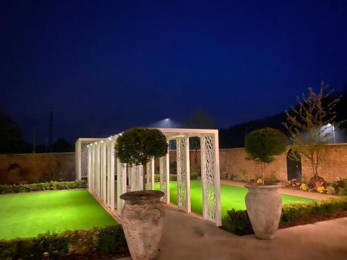a white gate with a green lawn at night at Wildes Inns in Chesterfield